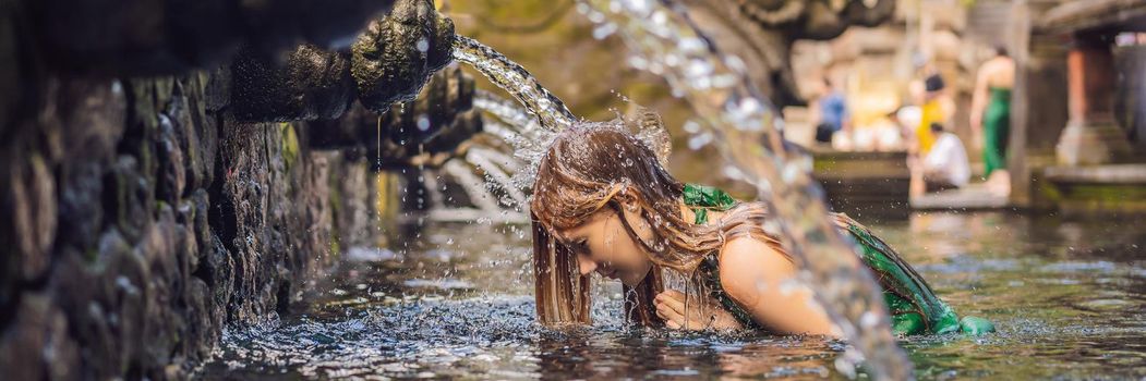 Woman in holy spring water temple in bali. The temple compound consists of a petirtaan or bathing structure, famous for its holy spring water. BANNER, LONG FORMAT