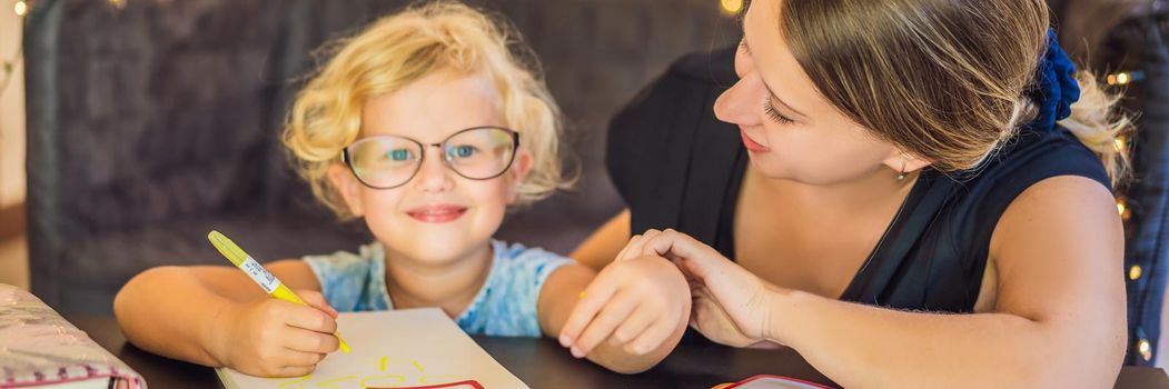 A teacher, a tutor for home schooling and a teacher at the table. Or mom and daughter. Homeschooling. BANNER, LONG FORMAT