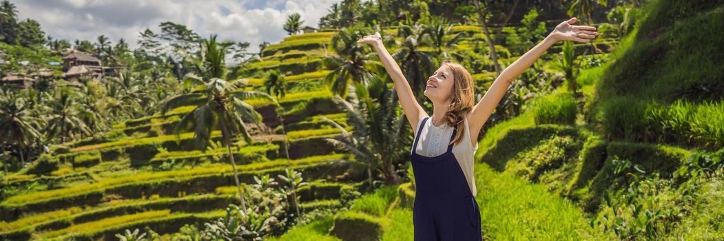 BANNER, LONG FORMAT Beautiful young woman walk at typical Asian hillside with rice farming, mountain shape green cascade rice field terraces paddies. Ubud, Bali, Indonesia. Bali travel concept.