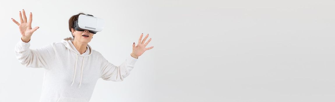 Modern technologies, future and people concept - Woman 40-50 years old wearing virtual reality glasses on white background.