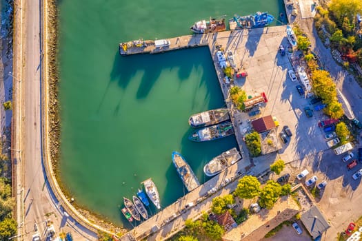 Aerial top view from drone to the seacoast and small marina with boats and yachts. Sea landscape with yachts from above