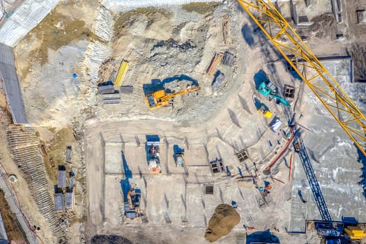 Construction equipment working at the construction site. Aerial view from drone