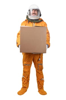 Astronaut wearing orange space suit and space helmet holding in hand blank square cardboard box isolated on white background. Delivery concept. Astronaut courier concept