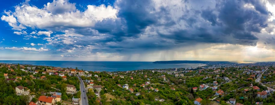 Amazing aerial panorama from a drone of exciting stormy clouds and rain over the sea.