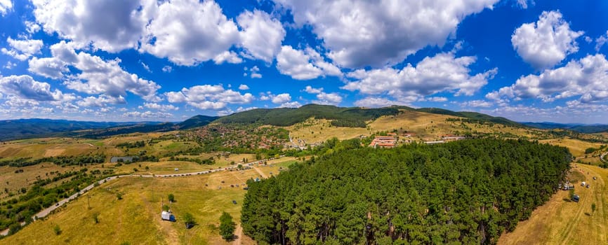 Beautiful aerial panorama of mountain village at hills and beautiful clouds