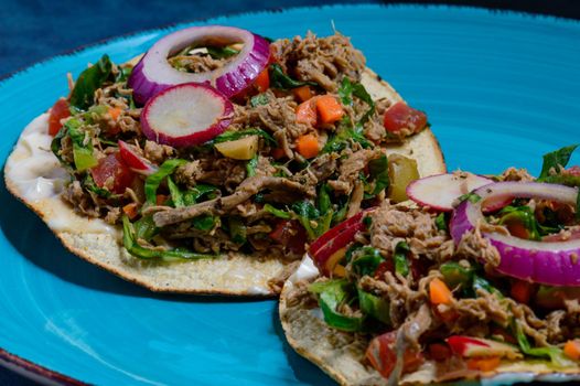 Beef salpicon on corn tostadas. Mexican spicy beef steak salad with carrot, olives, chili, onion and radish. Delicious Mexican cuisine