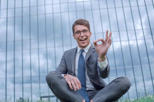happy businessman showing OK gesture sitting near his office. photo with copy space