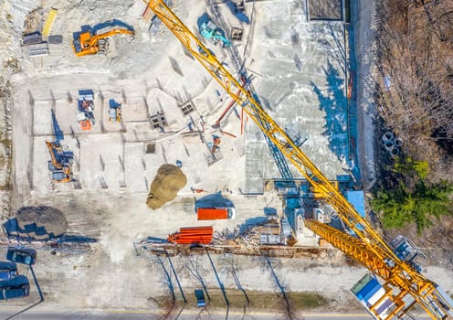 Construction equipment working at the construction site. Aerial view from drone