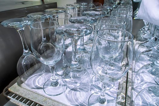 Rows of empty wine glasses close up. Glass goblets on the table. Restaurant bar concept