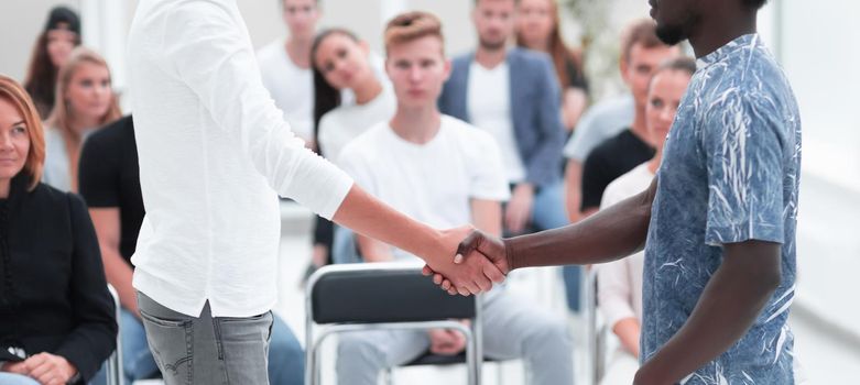 young men shake hands before the start of the briefing. business and education