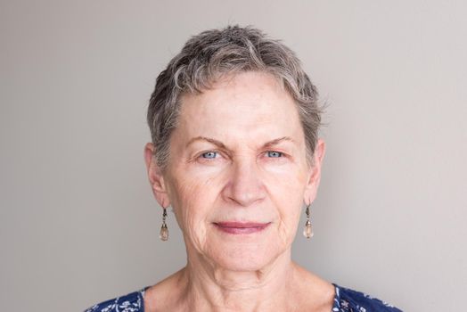 Portrait of older woman with short grey hair and blue eyes