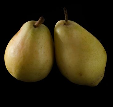 two ripe, juicy pears on a black background