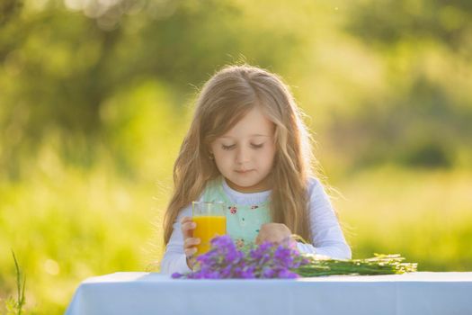 girl with a glass of orange juice in nature