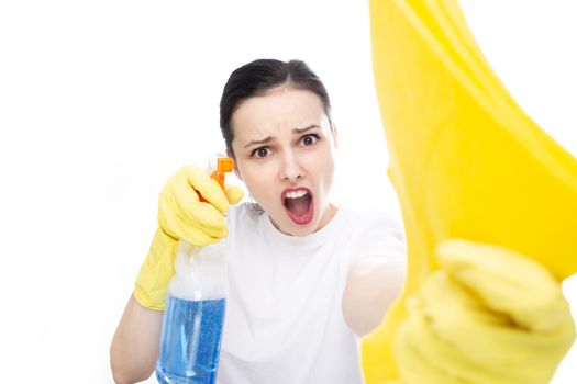 funny woman in yellow gloves holds rags and cleaning agent in her hands, white studio background. High quality photo