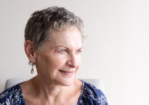 Side view of older woman with short grey hair and blue eyes (selective focus)