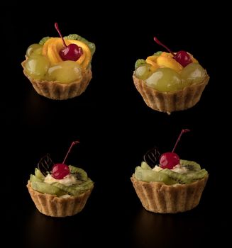 Fruit dessert cake with cherries, shekolad, grapes sponges, kiwi slices and orange slices, on a black background isolated, collage