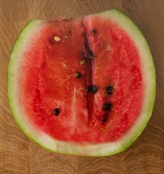Half of ripe watermelon on a wooden board close up