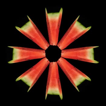 Watermelon cut into equal parts, set in the shape, of a circle on a black background in isolation, view from the top