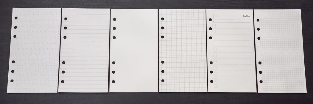 Different paper for notepad mocap on a black wooden background. BANNER, LONG FORMAT