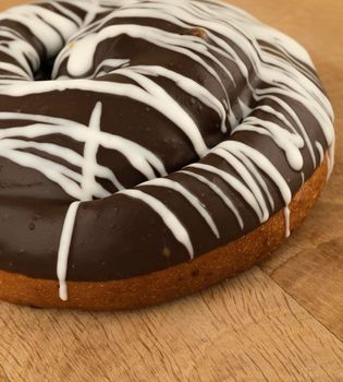 bun covered with chocolate, on a wooden board, close-up