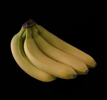 A bunch of several ripe bananas on a black background, isolated