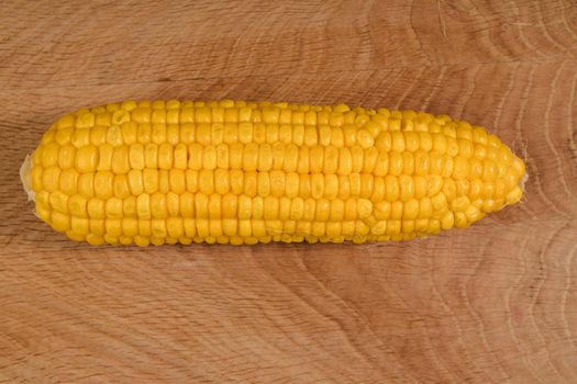 Ripe corn in a roach peeled from husk on a wooden board