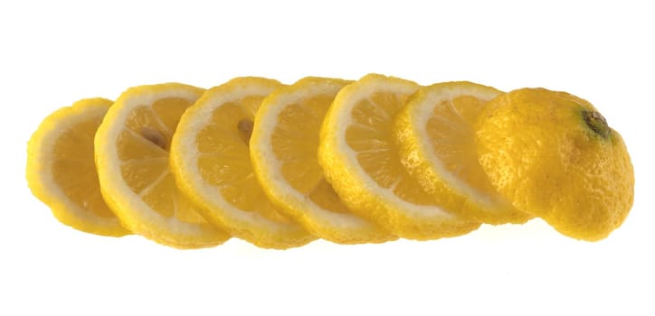Lemon sliced in wedges and laid out in a row on a white background