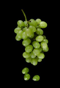 White pouring grapes, with large cubes, on a black background isolated