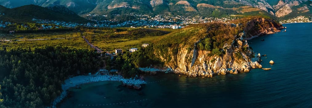 Aerial top evening view drone above Adriatic sea Montenegro. panoramic sunny marine mountain sunset. summer nature wallpaper. dark calm water rock. mountains coast seaside. Amazing outdoors view town