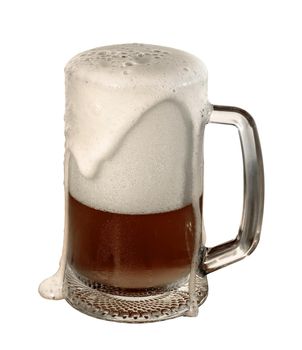 A glass with beer and a large layer of foam that partially flows over the edges of the glass