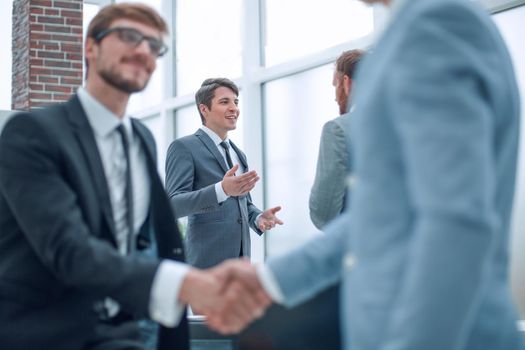 close up. happy young businessman shaking hands with his business partner. concept of cooperation