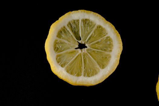 Five lemon slices lined up in a semicircle on a black background