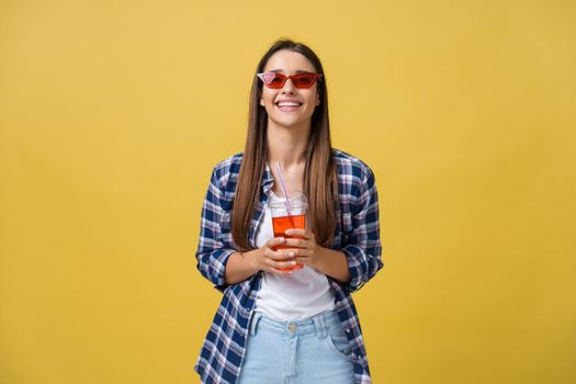 Young woman holding and drinking cold drink beverage in casual clothes. pretty girl smiling happy laughing looking at camera