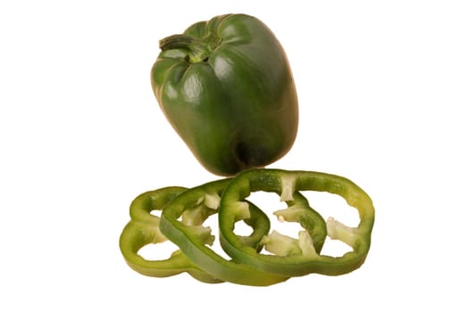 Green bell pepper, whole and sliced, on a white plate in isolation