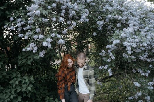 lovers embrace standing under lilacs