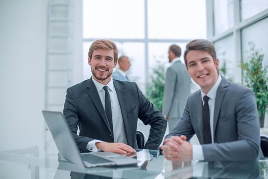 two smiling businessman sitting at his Desk. business concept