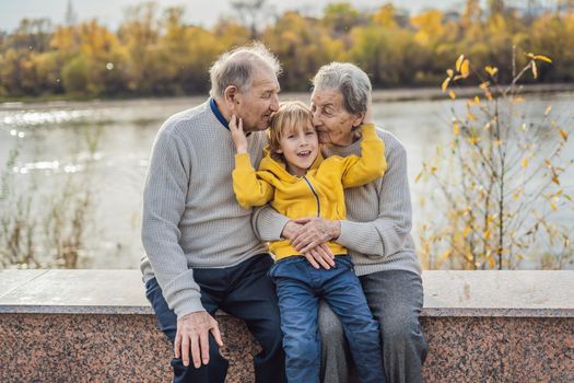 Senior couple with baby grandson in the autumn park. Great-grandmother, great-grandfather and great-grandson.