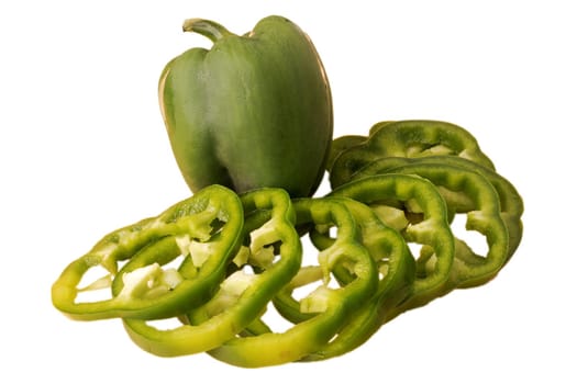 Green bell pepper, whole and sliced, on a white plate in isolation