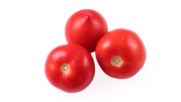 Three whole red tomatoes on a white background in isolation