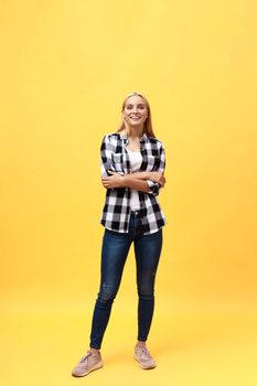 Full length laughing model in studio. looking at camera. isolated yellow background.