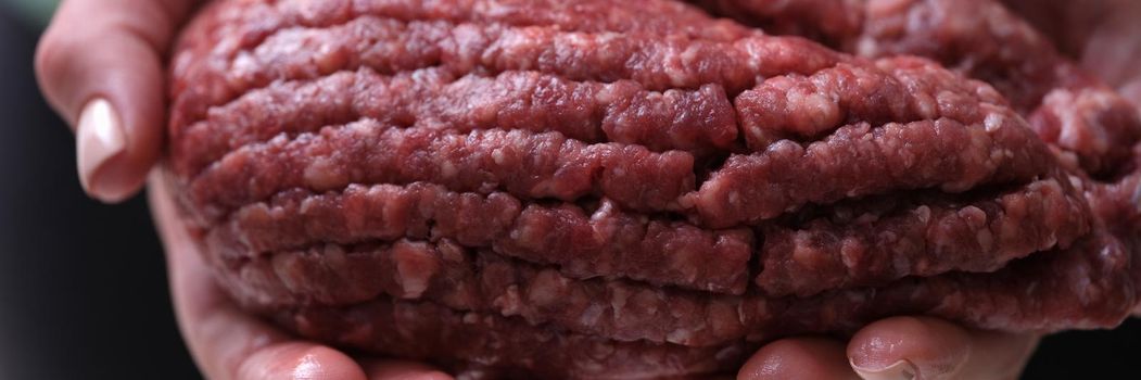 Female hands hold fresh red minced meat, close-up. Cooking organic food, burger. Traditional meatloaf, barbecue