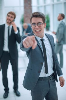 happy businessman in glasses pointing at you . business concept