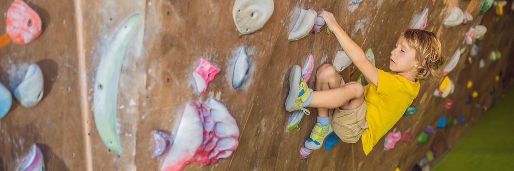 little boy climbing a rock wall in special boots. indoor. BANNER, LONG FORMAT