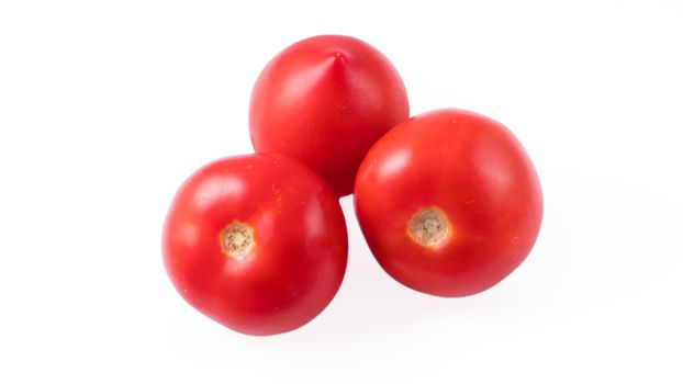 Three whole red tomatoes on a white background in isolation