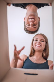 close up. young couple looking inside a cardboard box. delivery concept