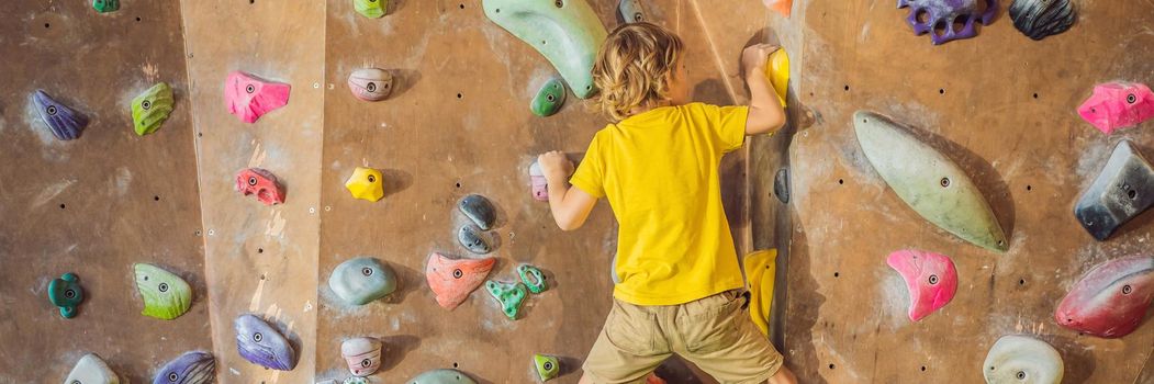 little boy climbing a rock wall in special boots. indoor. BANNER, LONG FORMAT