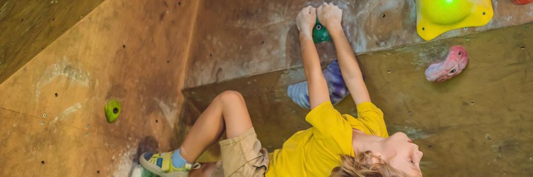 little boy climbing a rock wall in special boots. indoor. BANNER, LONG FORMAT