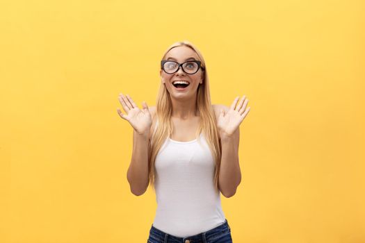 Happy stylish modern woman with modern shaped sunglasses laughing looking at you camera isolated on yellow background. Happiness concept.