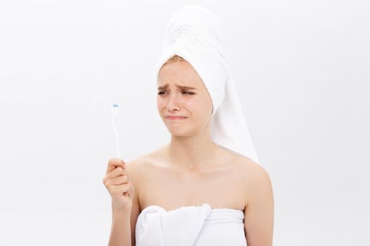 Sad young beautiful woman holding a toothbrush with disappointed facial expression