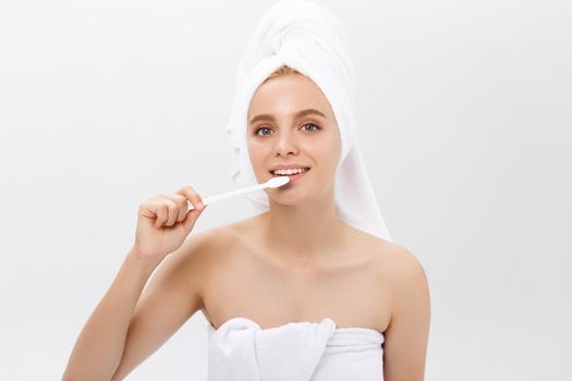 portrait of attractive caucasian smiling woman isolated on white studio shot head and shoulders face skin hand with tooth brush.